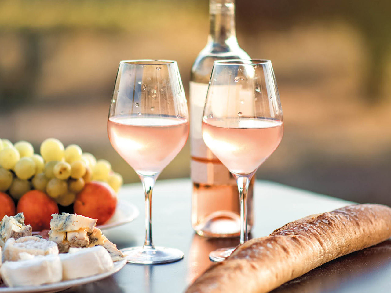 2 Gläser Roséwein, Brot, Kaese und Trauben